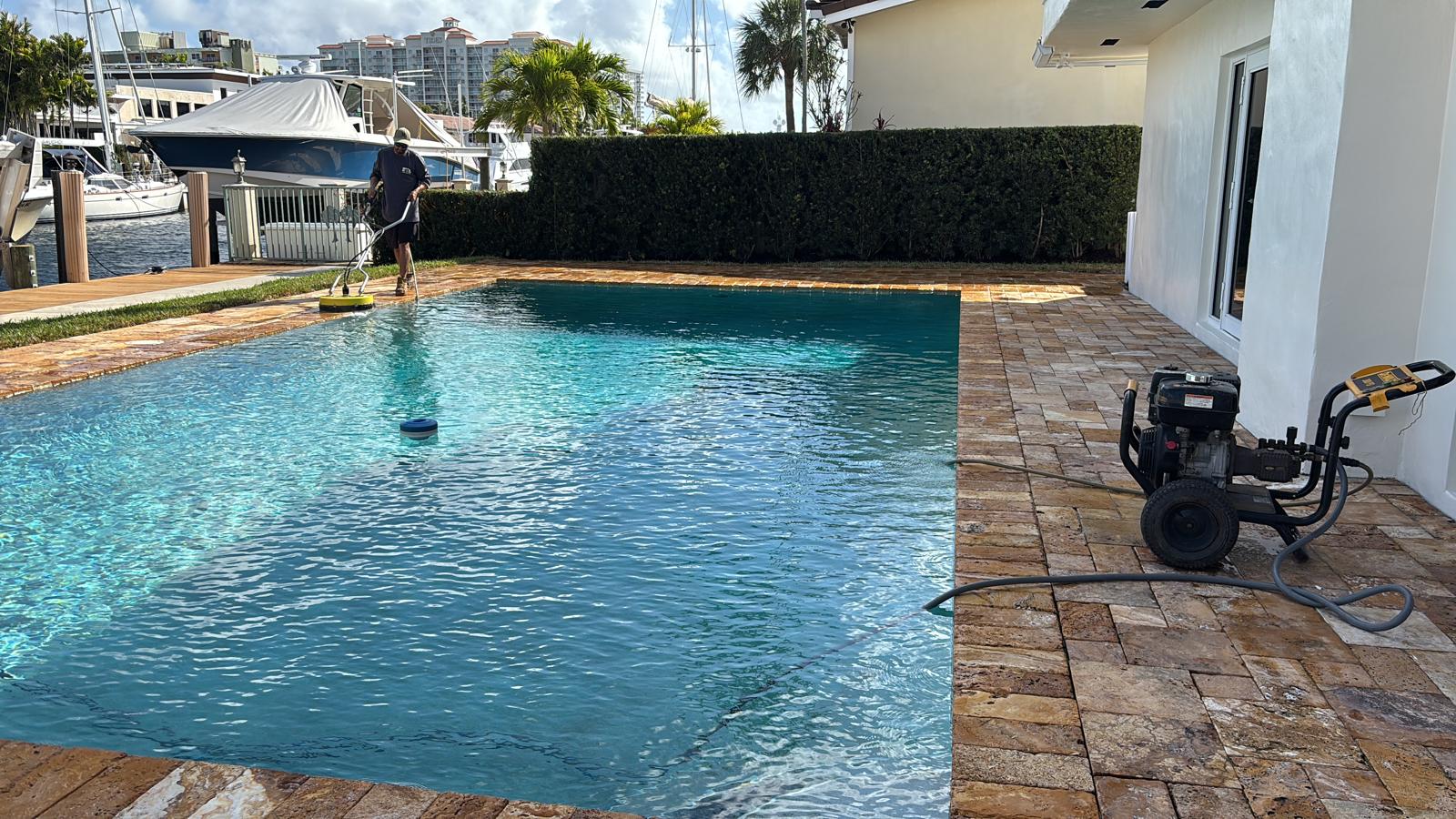Pressure washing pool deck and travertine pavers at a waterfront home
