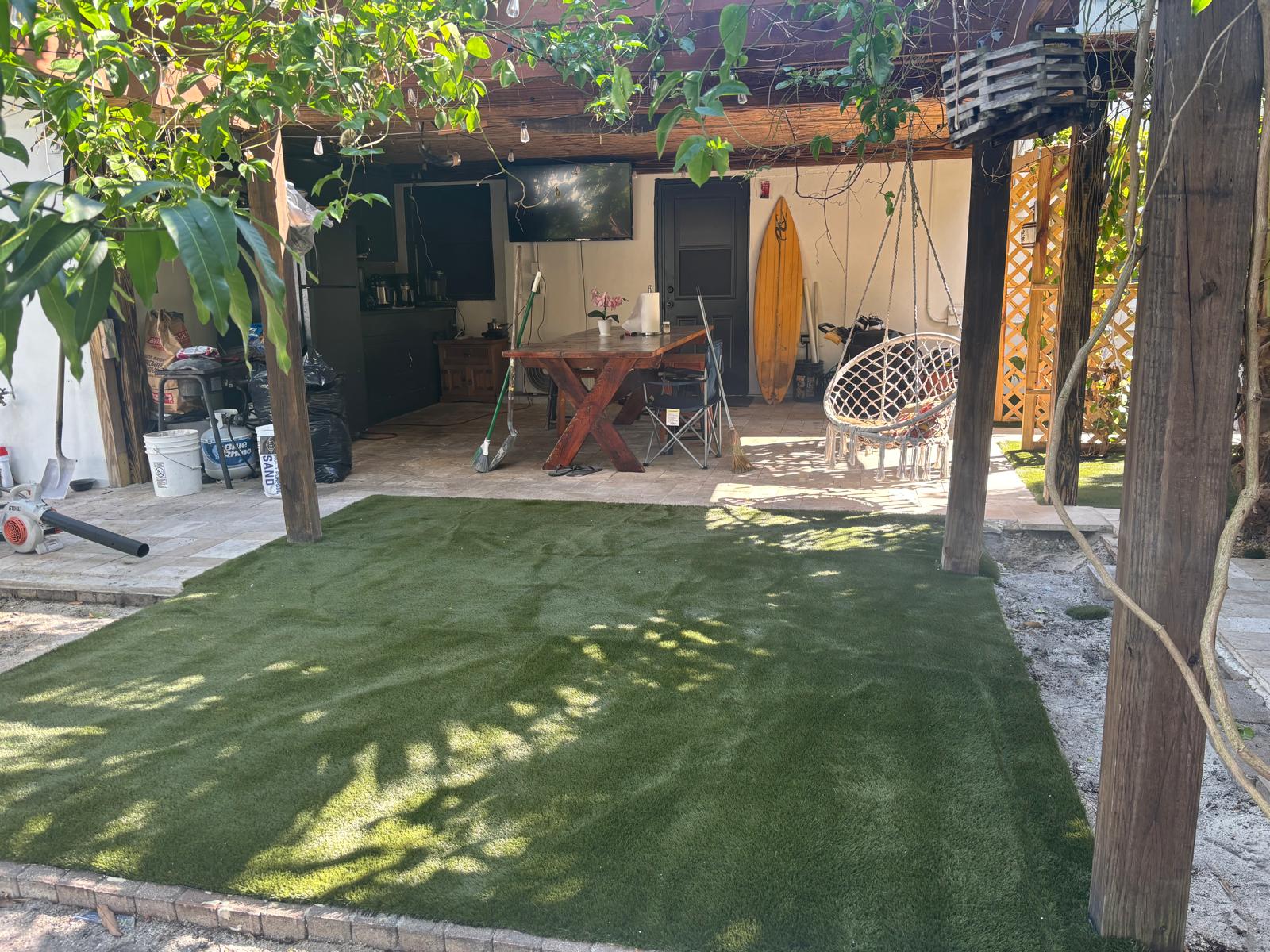 Artificial grass under a pergola patio with hanging chair