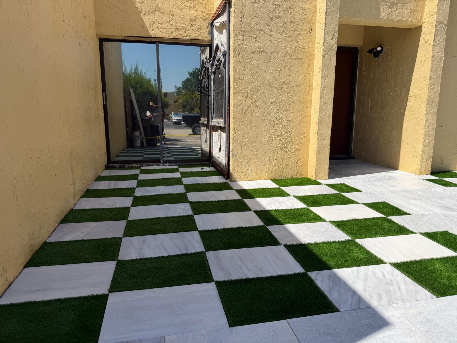 Artificial grass and marble paver checkerboard installation