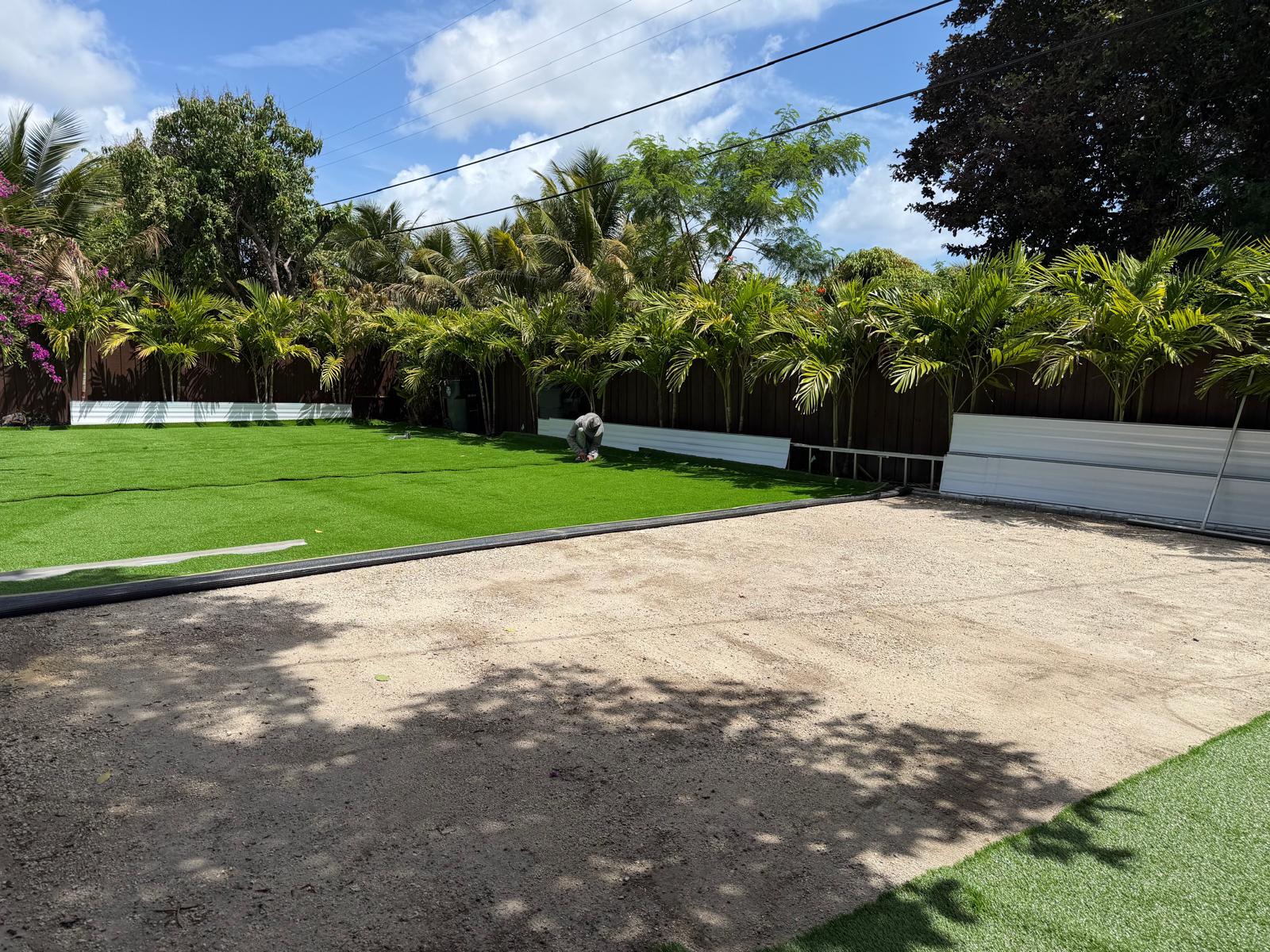 Artificial grass install on a tropical backyard with palms