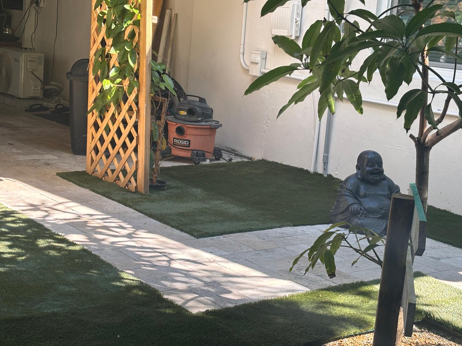 Travertine path with artificial grass borders in a private garden