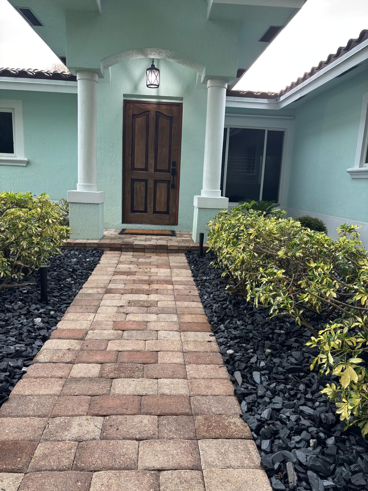 Brick paver walkway and entry steps with black mulch beds