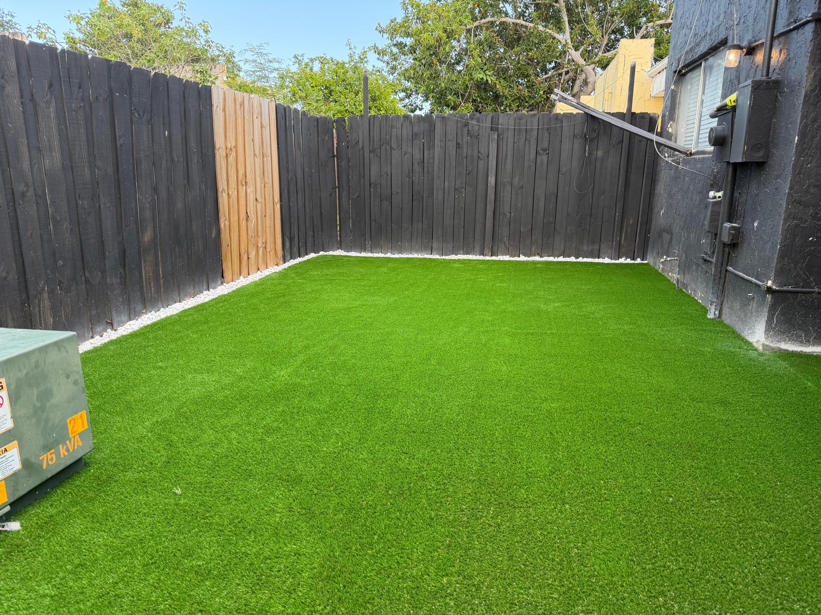 Synthetic turf yard install with white rock border